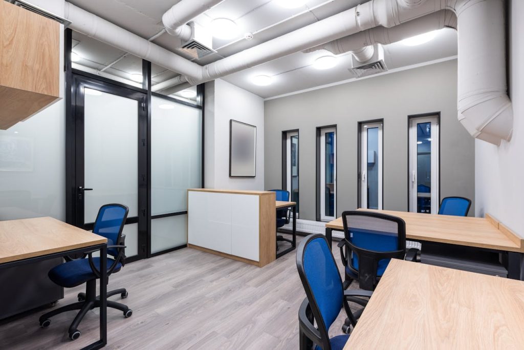 pexels-photo-7534210 Interior of new contemporary spacious workplace with wooden desks and blue office chairs